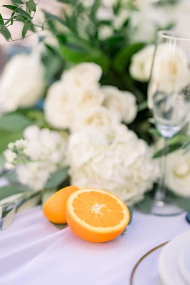 Close view of flower arrangement with cut orange for Sara & James’ Wedding