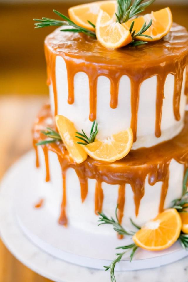 Close view of wedding cake with orange topping and slices of orange for Sara & James’ Wedding