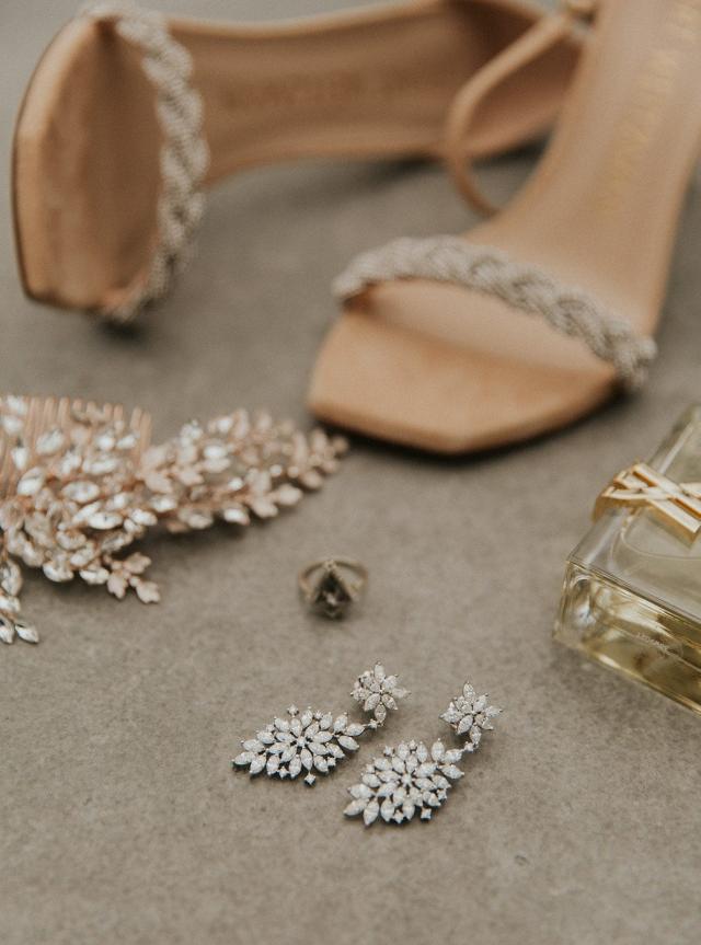 Close-up of bride's shoes, earrings, ring, and perfume for Ivanka & Victoria's wedding
