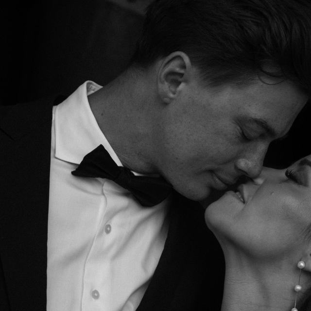Black and white photo of Groom kissing Bride for Lauren & Russell's Wedding